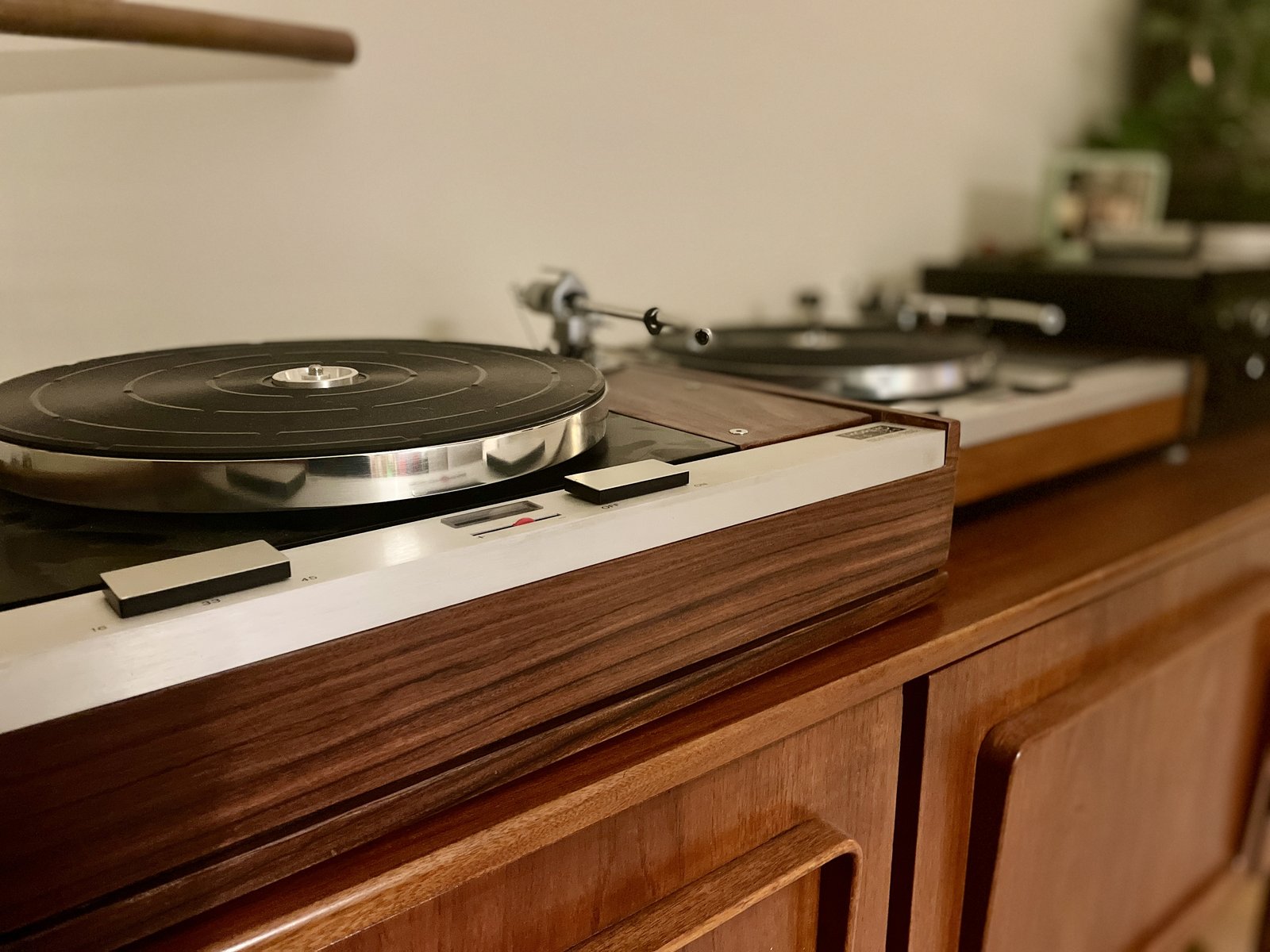 Turntable on a teak sideboard, a second turntable visible in the background