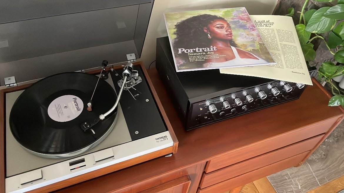 A record playing on a Thorens turntable, sleeve resting on the sideboard