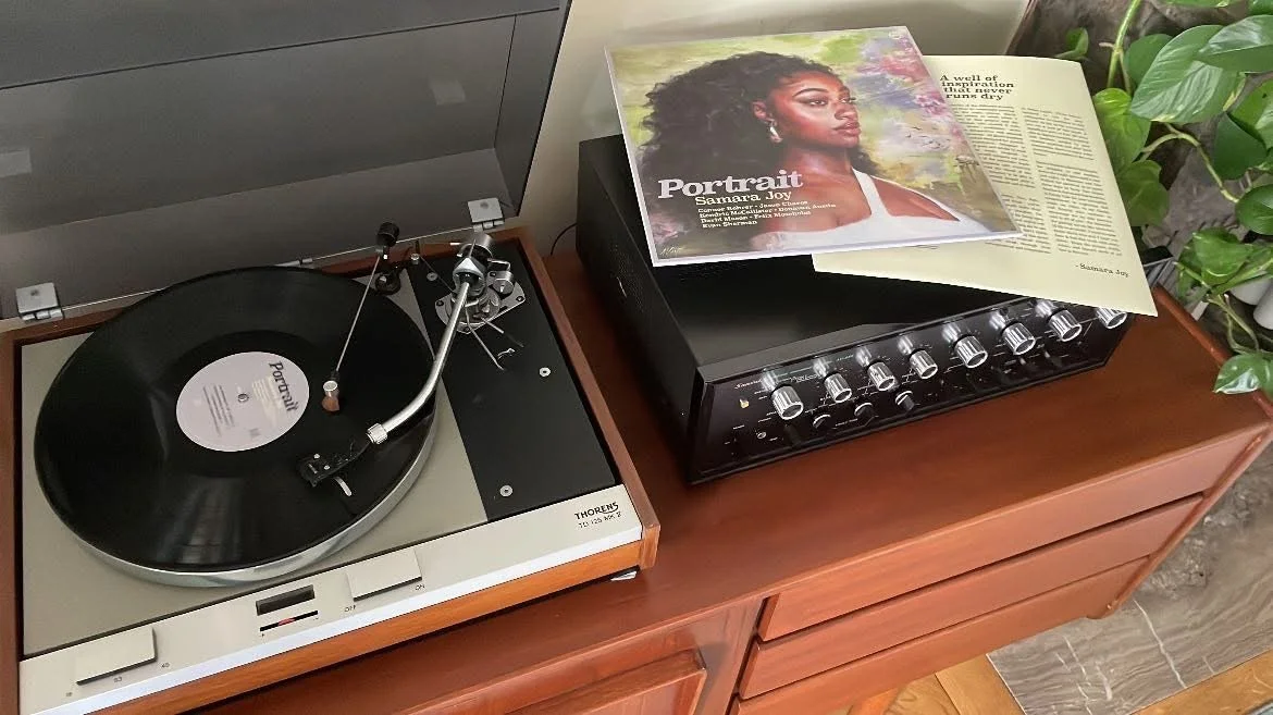 A record playing on a Thorens turntable, sleeve resting on the sideboard