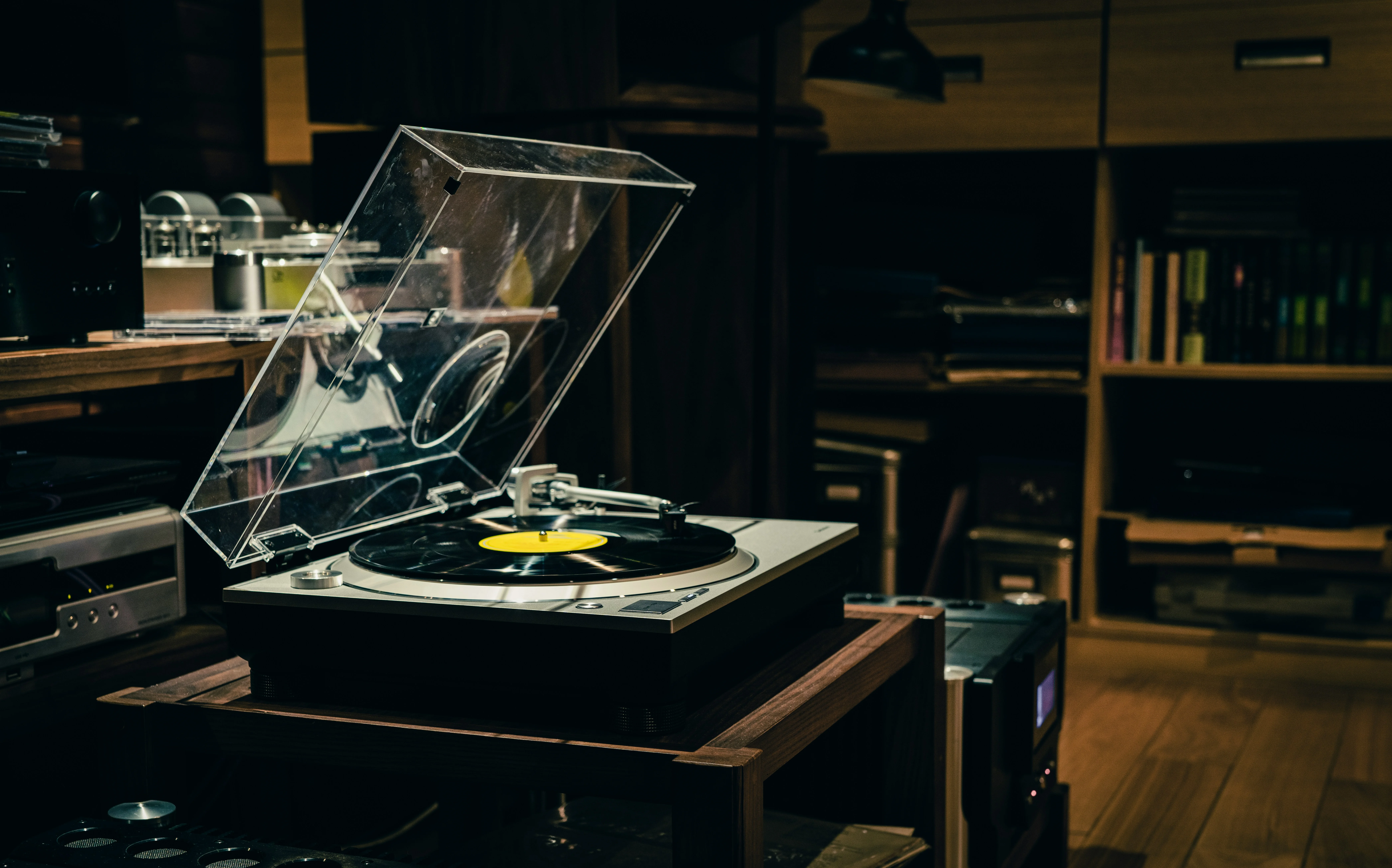 A turntable on a walnut sideboard, warm light, records in the background