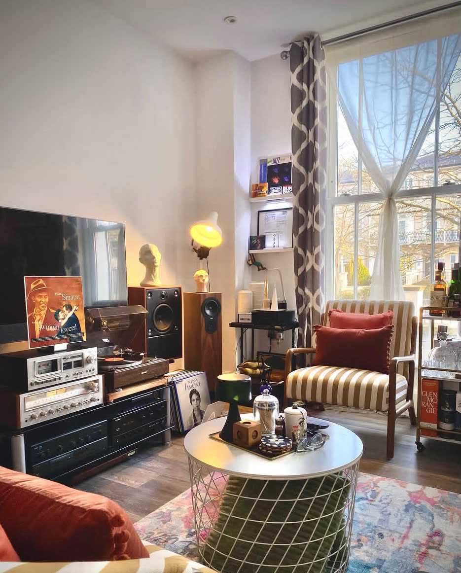 The full room, striped armchairs, bar cart and tall window, London