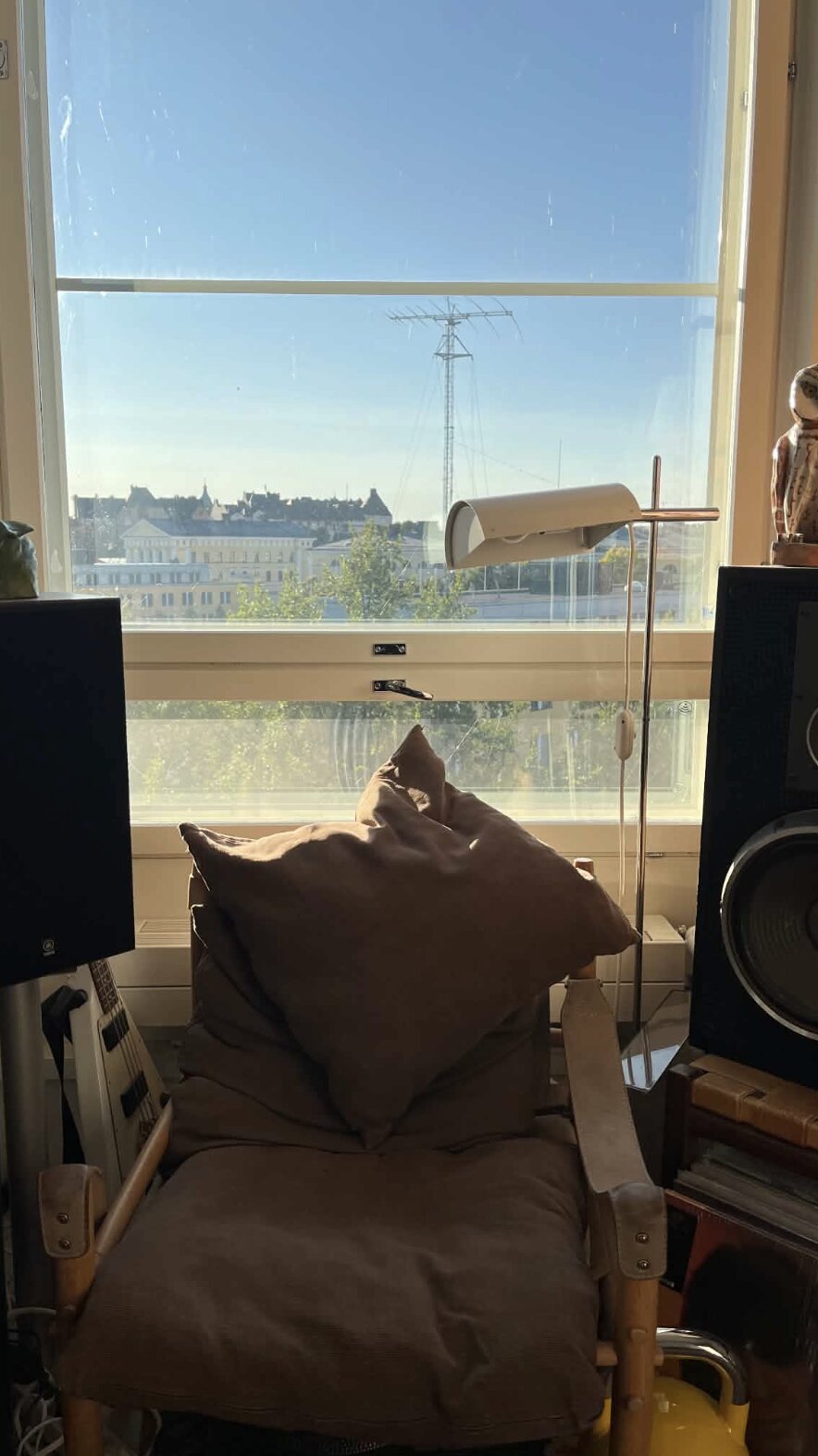 Fauteuil et coussins entre deux enceintes Yamaha, devant la fenêtre, tour d'antenne au loin