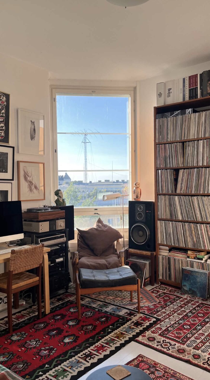 Coin de la pièce avec platine, enceinte Yamaha, chouette en céramique, tapis kilim rouge