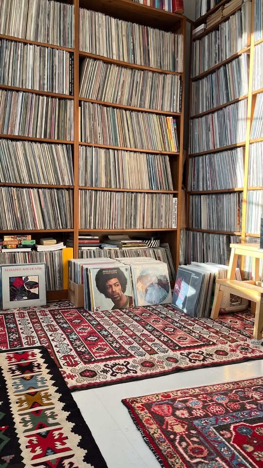 Étagères de disques du sol au plafond, tapis kilim superposés au sol
